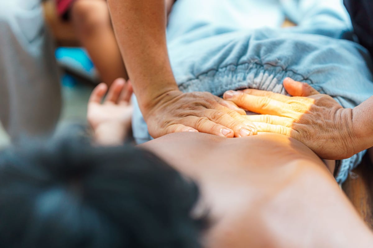 Hands working across a patient's back during a massage treatment